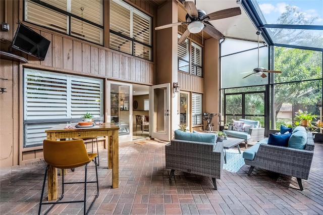 sunroom / solarium featuring a wealth of natural light and a ceiling fan