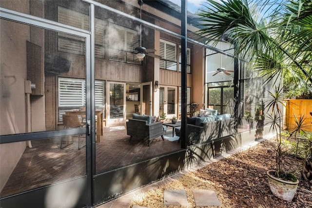 doorway to property featuring ceiling fan, an outdoor living space, and fence