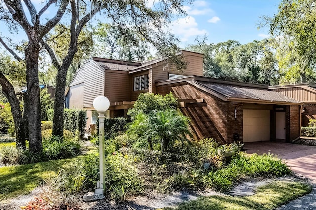 view of front of house featuring concrete driveway, brick siding, and an attached garage