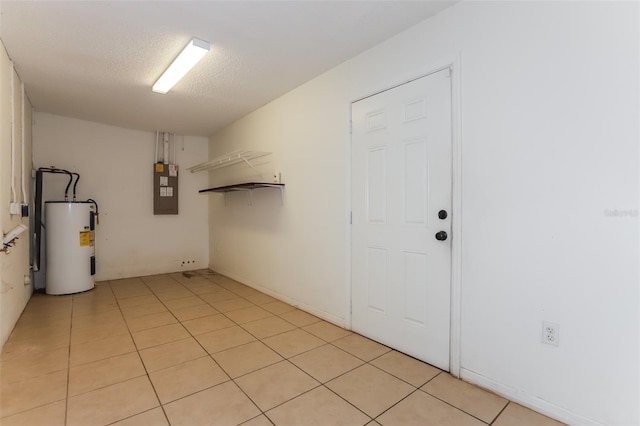 interior space with electric panel, water heater, a textured ceiling, and light tile patterned floors