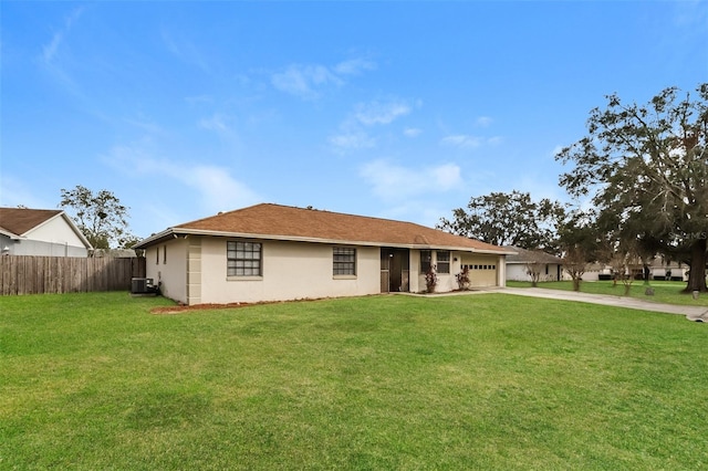 view of front of property featuring driveway, a garage, fence, a front lawn, and central AC