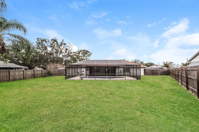 rear view of house with a patio, a fenced backyard, a lanai, a yard, and a fenced in pool