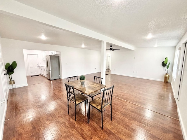 dining room featuring a textured ceiling, ceiling fan, hardwood / wood-style flooring, and baseboards