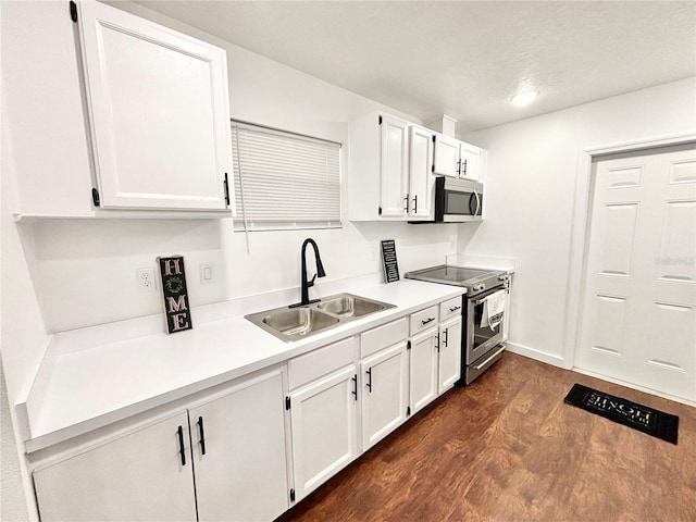 kitchen featuring white cabinets, stainless steel appliances, a sink, and light countertops