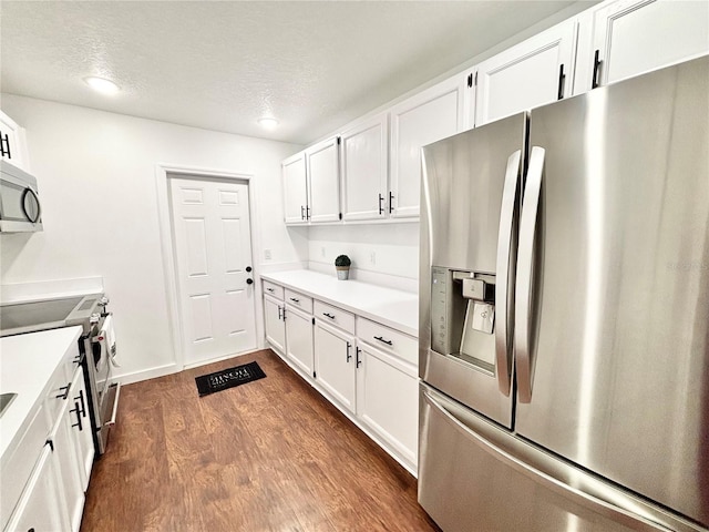 kitchen with dark wood finished floors, white cabinetry, stainless steel appliances, and light countertops