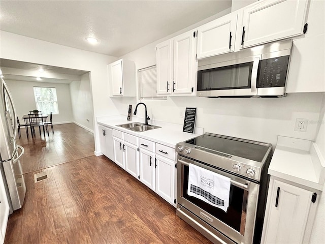 kitchen featuring stainless steel appliances, a sink, visible vents, white cabinets, and light countertops