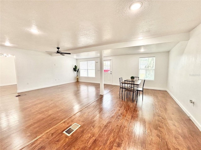 interior space featuring hardwood / wood-style flooring, baseboards, and visible vents