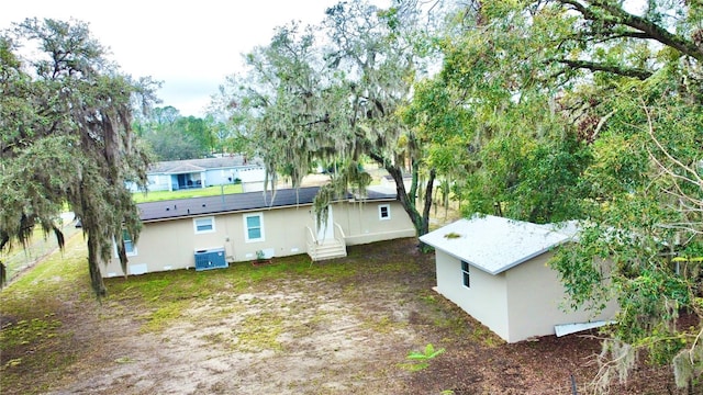 back of house featuring entry steps, cooling unit, and stucco siding