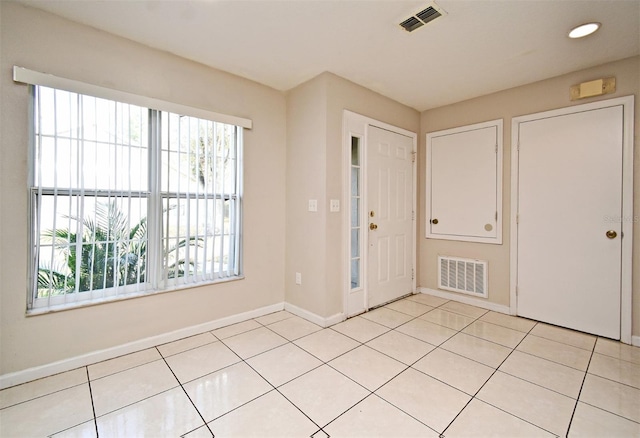 interior space with baseboards, visible vents, and light tile patterned flooring