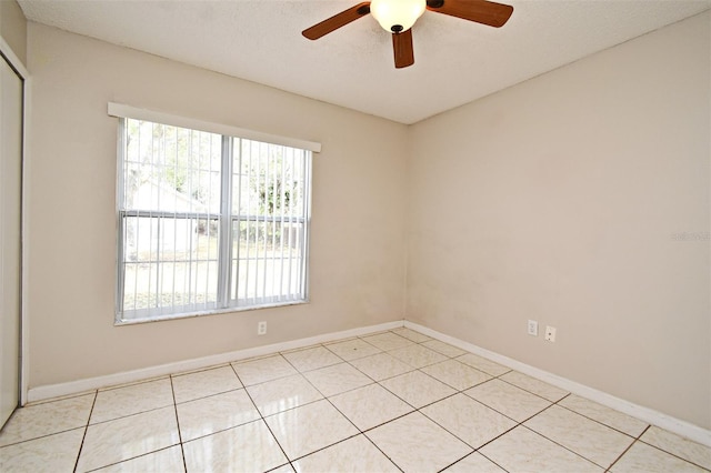 unfurnished room with a ceiling fan, baseboards, and light tile patterned floors