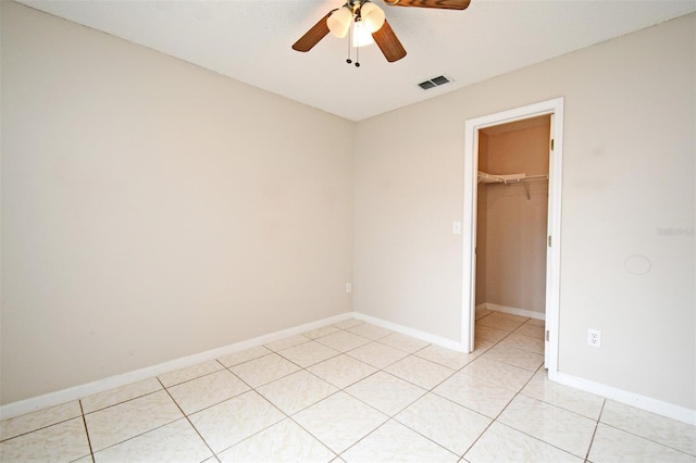 spare room with a ceiling fan, visible vents, baseboards, and light tile patterned flooring