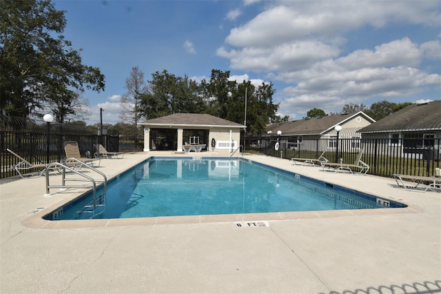 community pool featuring fence and a patio