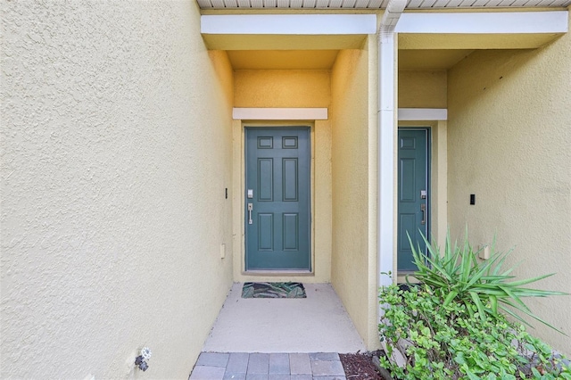 view of exterior entry with stucco siding