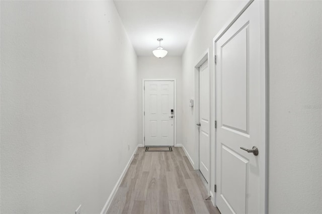 hallway with baseboards and light wood finished floors