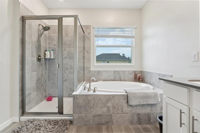 bathroom featuring wood finished floors, a shower stall, vanity, and a bath