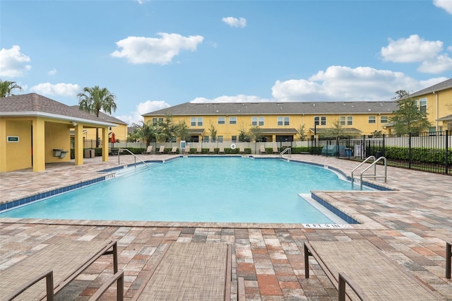 community pool with fence and a patio