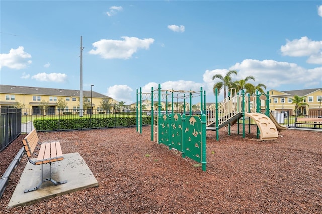 community playground with a residential view and fence