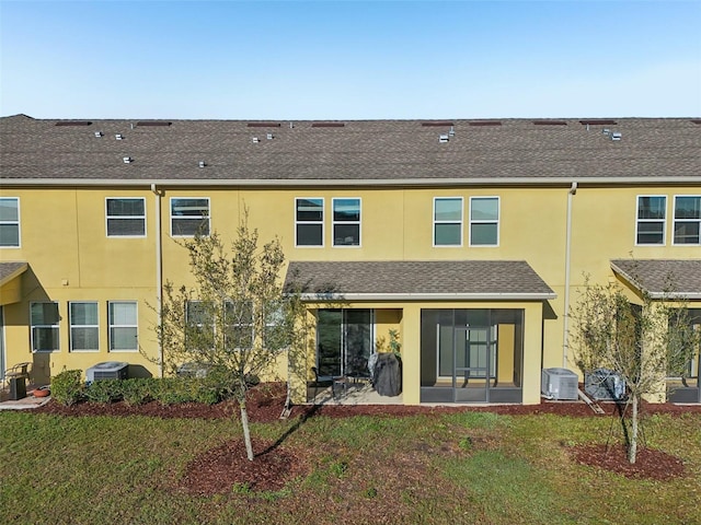 back of property featuring a shingled roof, a lawn, a patio area, central AC, and stucco siding