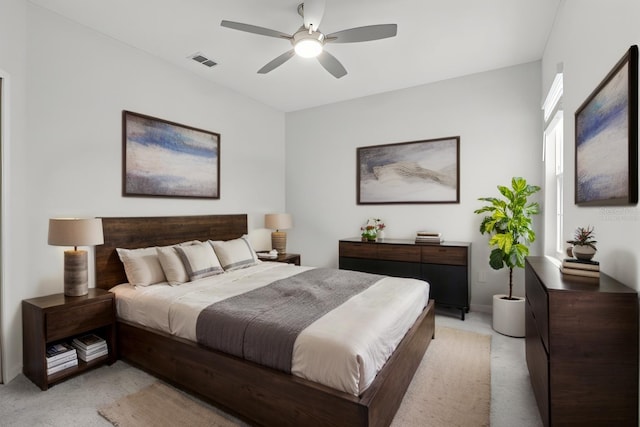 bedroom featuring a ceiling fan, visible vents, and light colored carpet