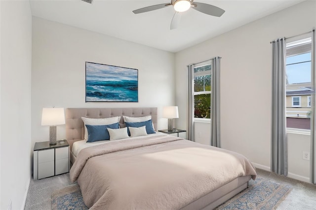 bedroom featuring a ceiling fan, light colored carpet, and baseboards