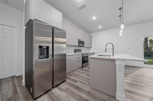 kitchen featuring stainless steel appliances, visible vents, light countertops, modern cabinets, and pendant lighting