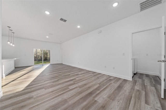 spare room with light wood-type flooring, baseboards, visible vents, and recessed lighting