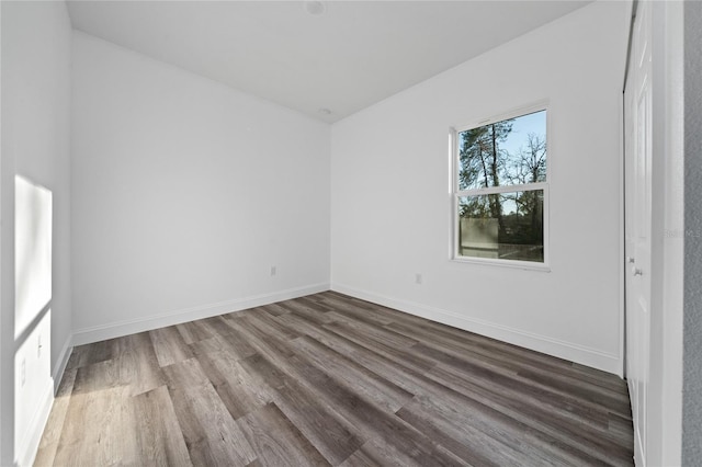 unfurnished room with baseboards and wood finished floors