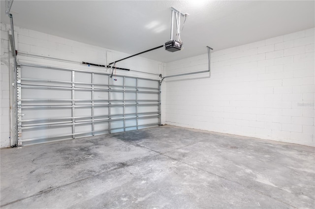 garage featuring a garage door opener and concrete block wall