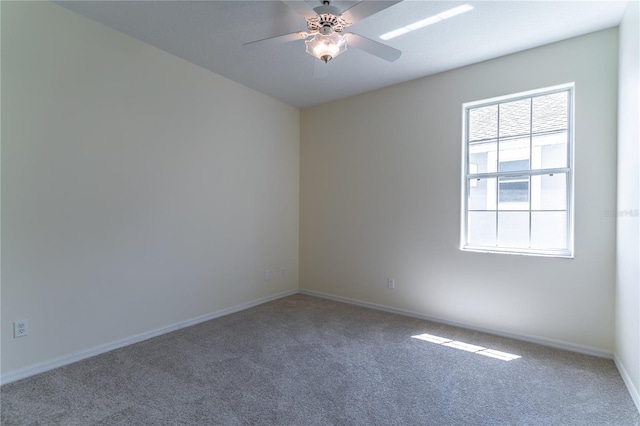 unfurnished room featuring baseboards, a ceiling fan, and carpet