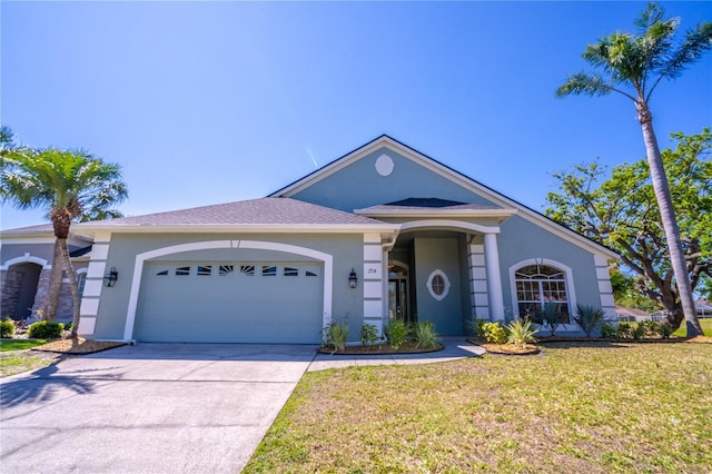 single story home with stucco siding, an attached garage, concrete driveway, and a front yard