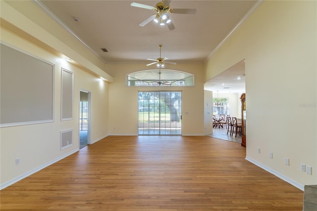 spare room featuring baseboards, crown molding, a ceiling fan, and wood finished floors