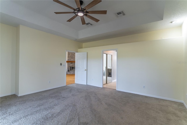 empty room with light carpet, baseboards, visible vents, and ceiling fan
