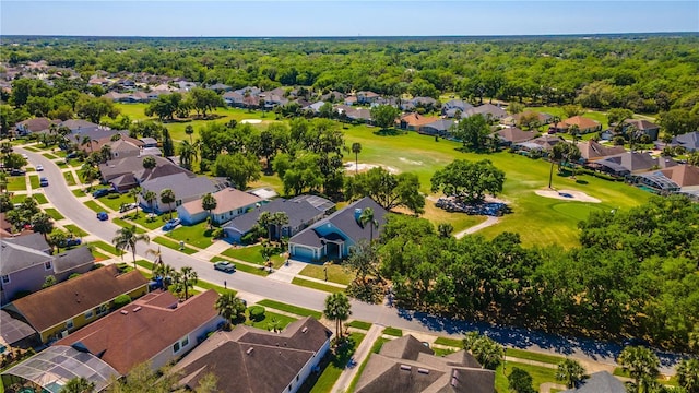 birds eye view of property featuring view of golf course, a forest view, and a residential view