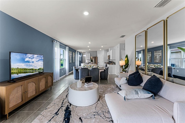 living area featuring dark tile patterned flooring, visible vents, and recessed lighting