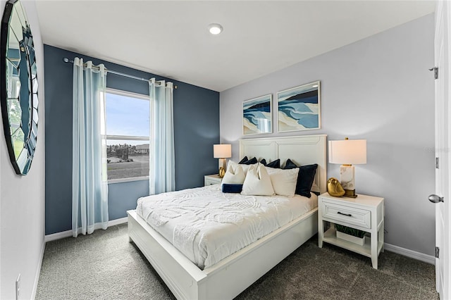 bedroom featuring dark carpet and baseboards