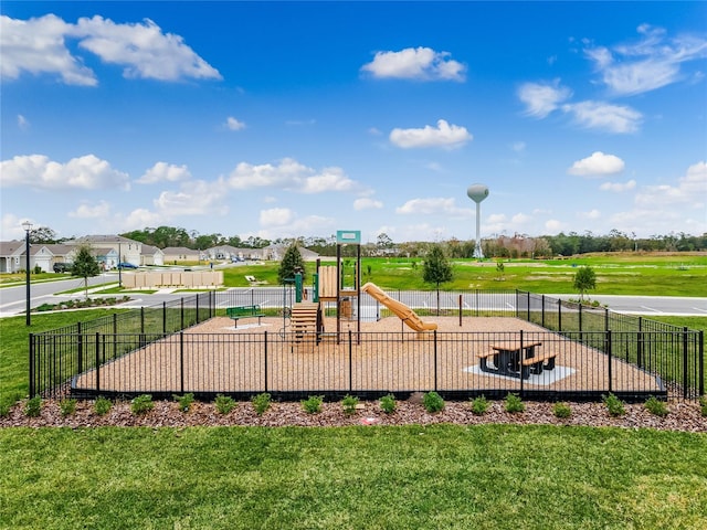 community jungle gym featuring a lawn, fence, and a residential view