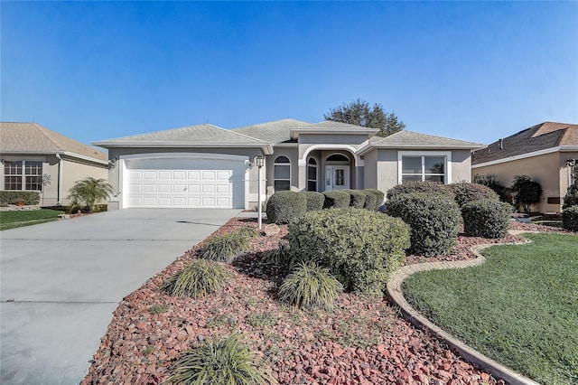 ranch-style house with roof with shingles, stucco siding, concrete driveway, an attached garage, and a front lawn