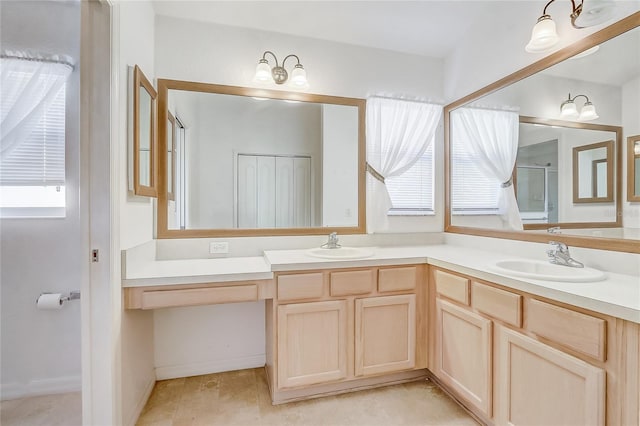 bathroom featuring double vanity, a sink, and a shower with shower door