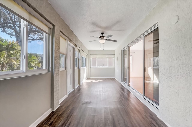 unfurnished sunroom with ceiling fan