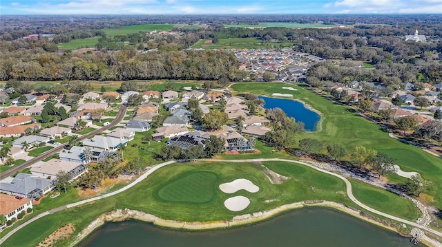 drone / aerial view featuring view of golf course, a water view, and a residential view