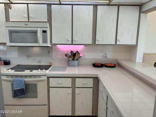 kitchen with white appliances, tasteful backsplash, and tile counters