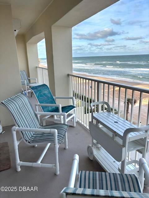 balcony featuring a water view and a beach view