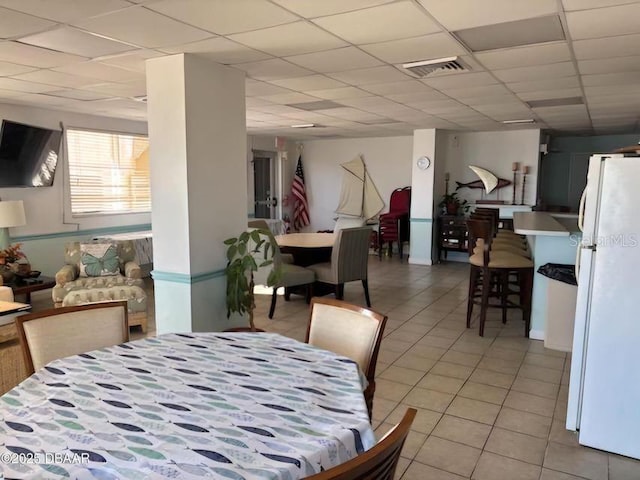 dining room with light tile patterned floors, a paneled ceiling, and visible vents