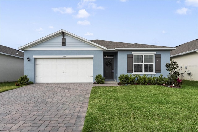 ranch-style house with decorative driveway, an attached garage, stucco siding, and a front yard