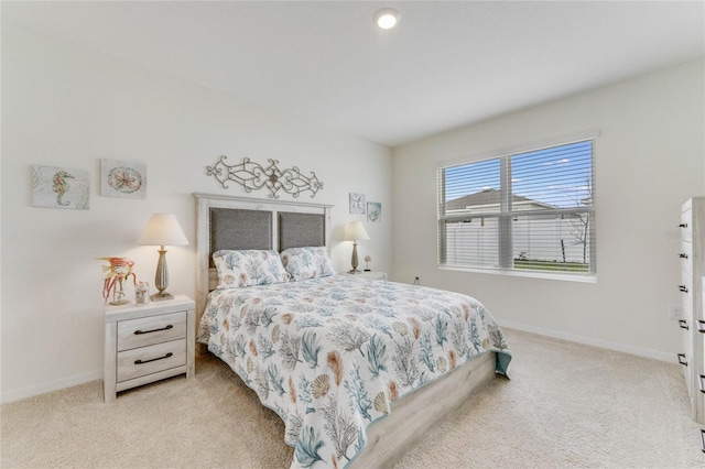 bedroom with light colored carpet and baseboards