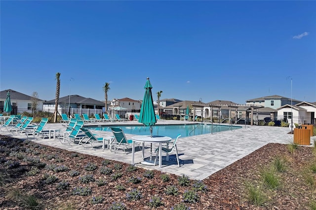 community pool featuring a residential view, a pergola, fence, and a patio