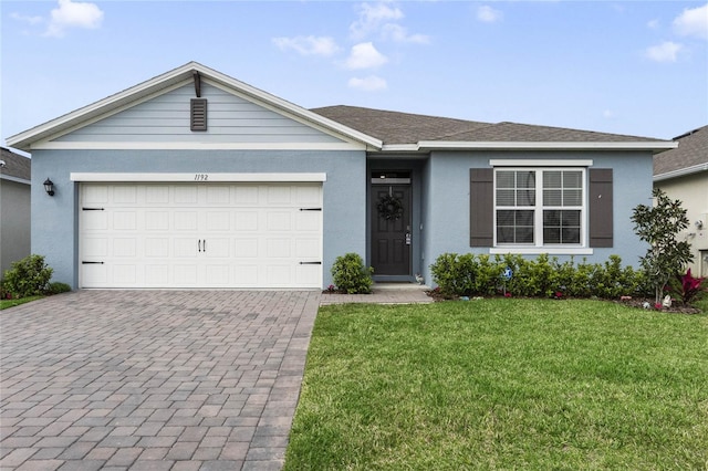 ranch-style house with a garage, stucco siding, and a front yard