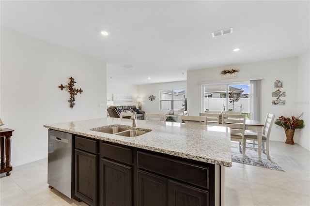 kitchen with a center island with sink, visible vents, stainless steel dishwasher, a sink, and dark brown cabinets