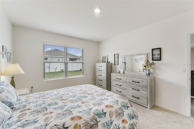 bedroom featuring light carpet and baseboards