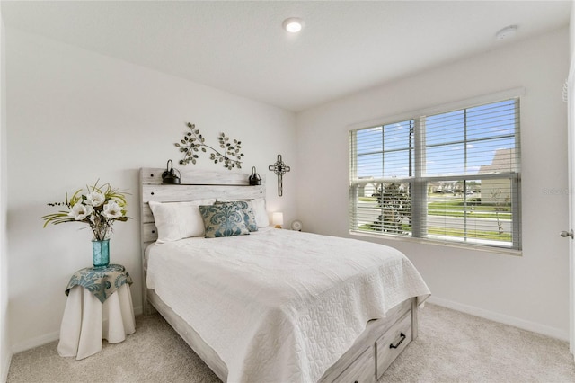 bedroom featuring light carpet and baseboards